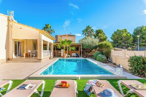 A pool area with lounge chairs, a table with a drink tray, and a covered seating area with a view of the pool. - Villa Mila - Five Bedroom Villa, Sleeps 10 (Calp)