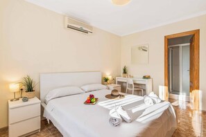 A hotel room with a bed, bedside table, desk, and a door leading to a shower area. - Villa Mila - Five Bedroom Villa, Sleeps 10 (Calp)