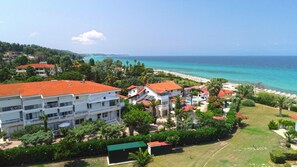 A coastal hotel with multiple buildings, a swimming pool, and a beach view. - Villa George (Kassandra)