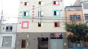 A hostel with colorful window frames and a sign advertising 'UMBRELLA BIKER'. - CONQUISTADOR HOTEL (Lima)