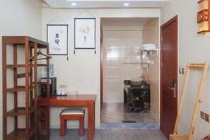 A room with a wooden desk, a chair, a hanging picture frame, a bathroom with a sink and towel rack, and a wooden ladder. - Yasu Inn (Kunming Dianchi Scenic Area) (Kunming)