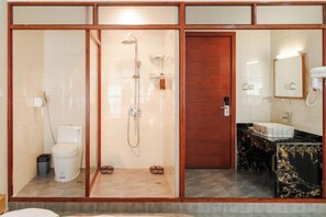 A bathroom with a glass-enclosed shower, a toilet, a sink with a marble countertop, and a wooden door. - Yasu Inn (Kunming Dianchi Scenic Area) (Kunming)