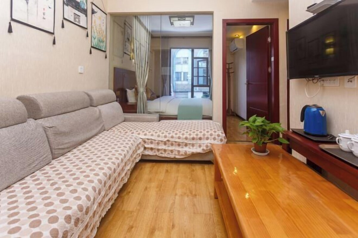 A cozy living room with a sofa, a coffee table, and a TV.