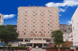 A multi-story hotel with a uniform facade, multiple windows, and a sign indicating it is a hotel.