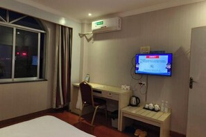 A hotel room with a bed, a desk, a chair, a TV mounted on the wall, and a small table with cups and a kettle. - Du an Hotel (Du'an)