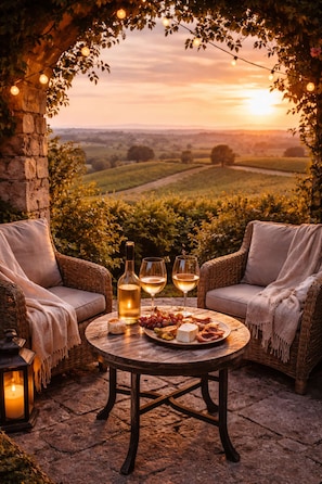 An outdoor seating area with wicker chairs, a round table, and a bottle of wine. - Loft Cosy - Hypercentre - Sauna - 200m2 - Wifi (Graulhet)