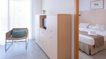 Une chambre d’hôtel avec un lit, une chaise, une télévision et un placard.