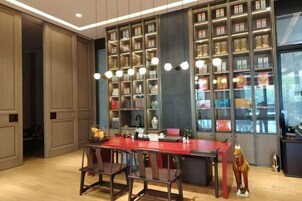 Una cocina moderna con una isla central, iluminación colgante y estanterías empotradas.