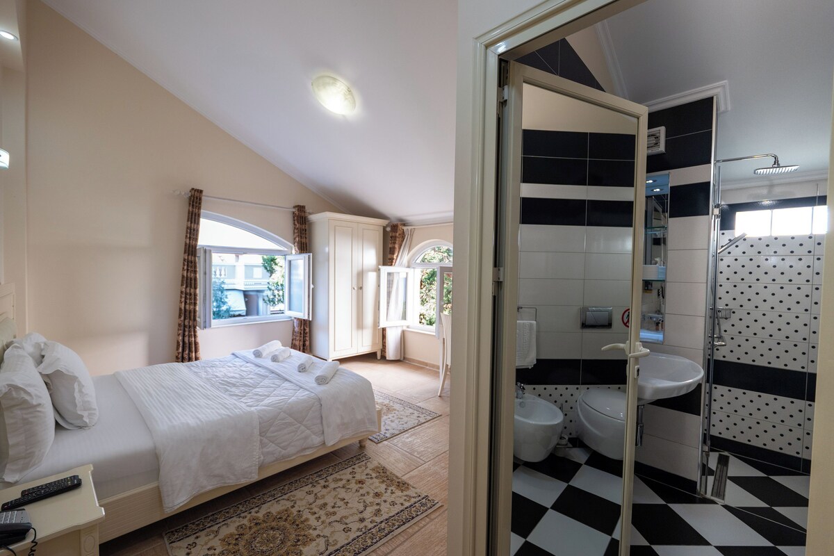 Une chambre à coucher avec un lit, une table de chevet et une fenêtre avec des rideaux.