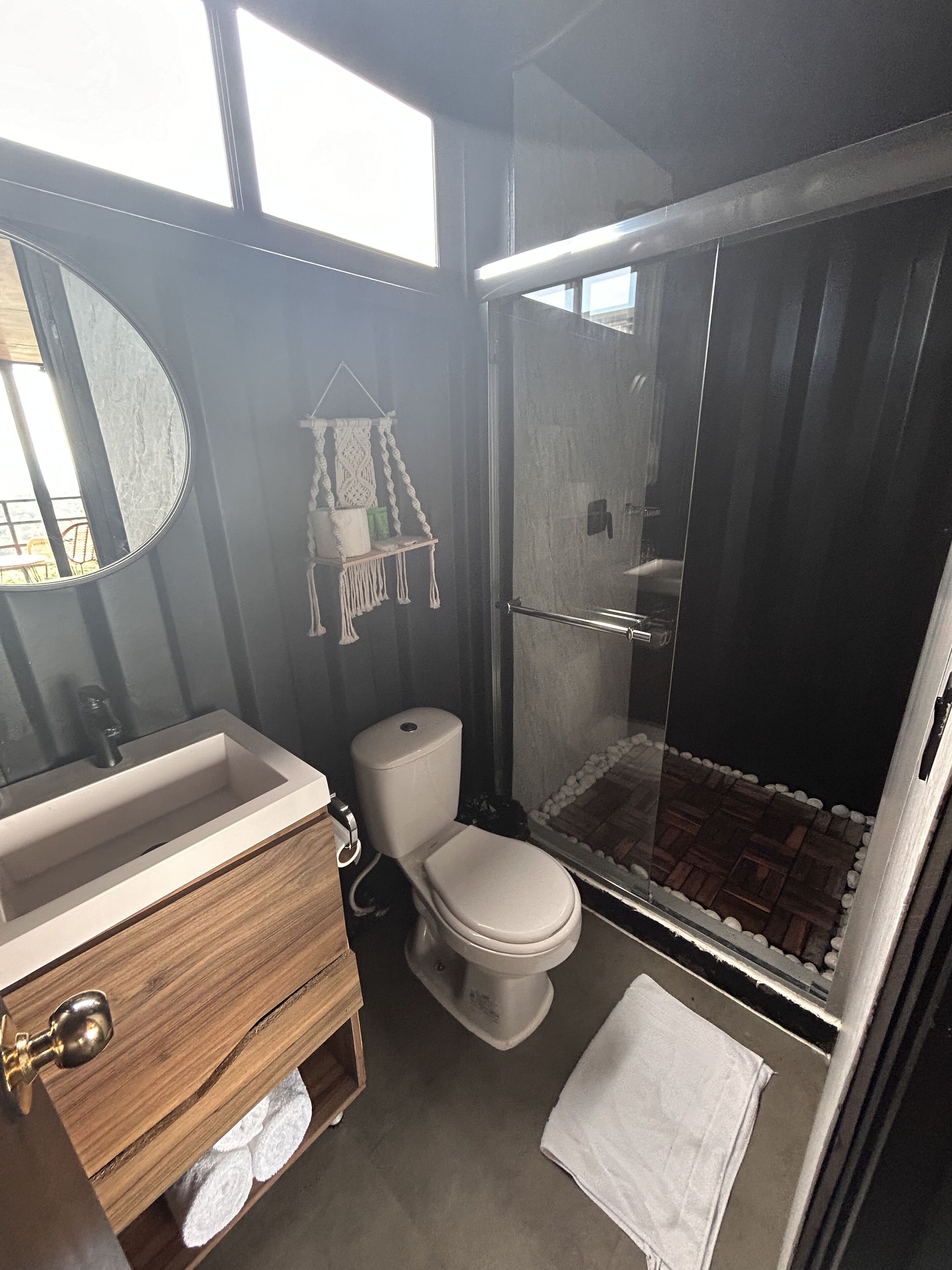 Ein Badezimmer mit einem Holzkosmetikschrank, einer Toilette und einer Duschkabine.