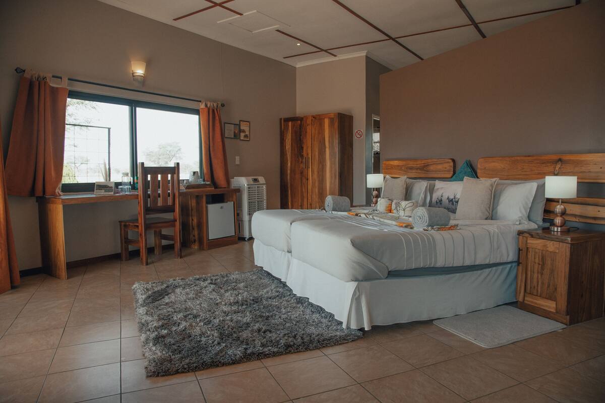 Een slaapkamer met een bed, een bureau en een stoel.