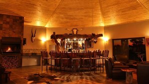 Un intérieur chaleureux avec une cheminée, un coin bar et un espace repas.