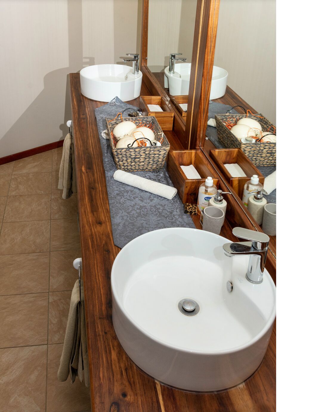 Un baño con dos lavamanos, un espejo grande y un mueble de tocador de madera.