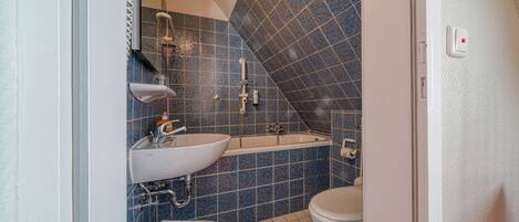 Ein Badezimmer mit einem weißen Waschbecken, einer Badewanne und einer Toilette.