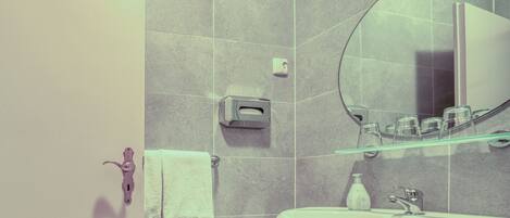 A bathroom with a white sink, a mirror, and a towel rack.