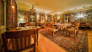 Comedor con mobiliario de madera, alfombra estampada y candelabro.