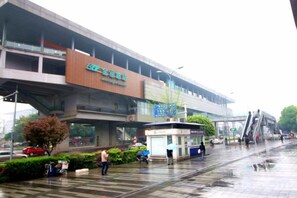 A train station with a covered walkway, ticket machines, and a pedestrian area. - Chongqing Yueyou Hotel North New District Qibo Hotel (Chongqing)