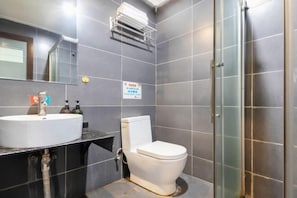Ein Badezimmer mit einem weißen Waschbecken, einer Toilette und einer Duschkabine aus Glas.