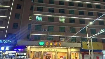 Un hotel con un cartel que dice 'VIP HOTEL' y un letrero de neón encima.