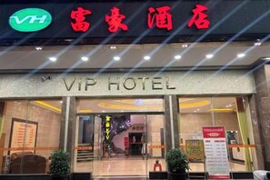 De gevel van een hotel met een bord waarop 'VIP HOTEL' staat en een logo erboven.