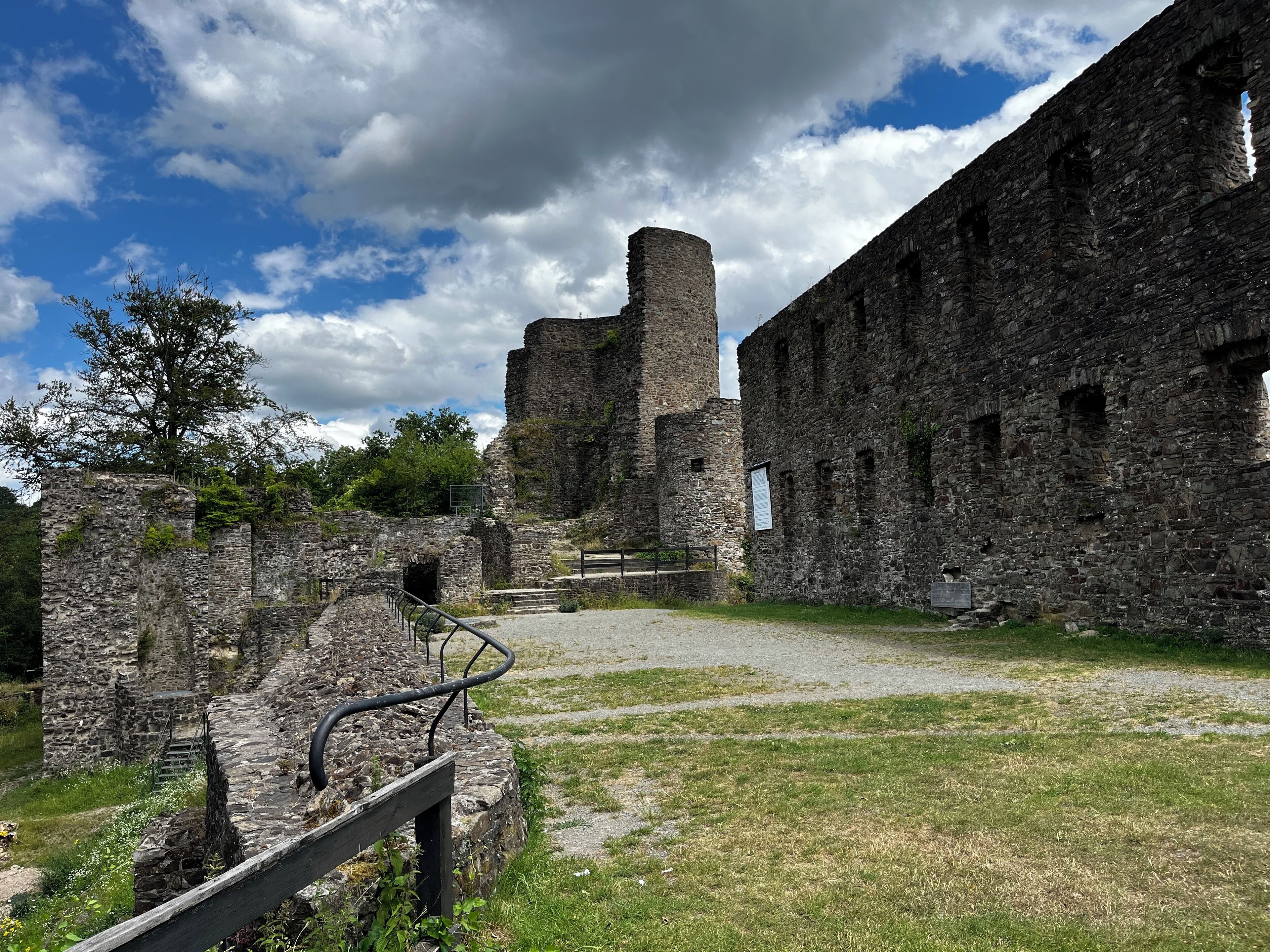 Una estructura de piedra antigua con ruinas y un área cubierta de césped.
