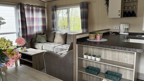 A compact kitchenette with a built-in stove, a coffee maker, and a small sink. - Vacation chalet on a campsite (Windeck)
