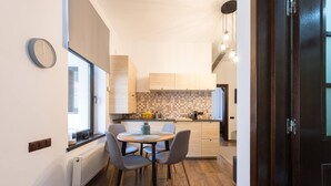 Eine moderne Küche mit Essbereich, Holzschränken, einer gefliesten Spritzschutzwand und einem Fenster für natürliches Licht.