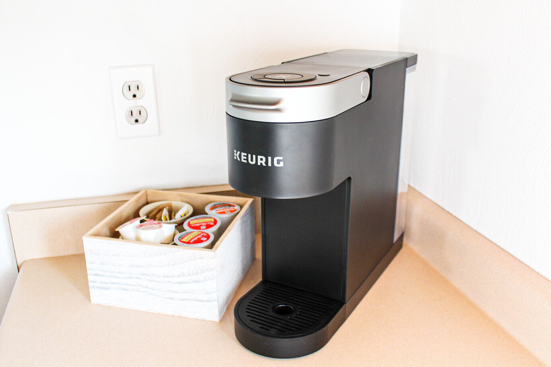 Una cafetera Keurig sobre una encimera con una caja de cápsulas de café.