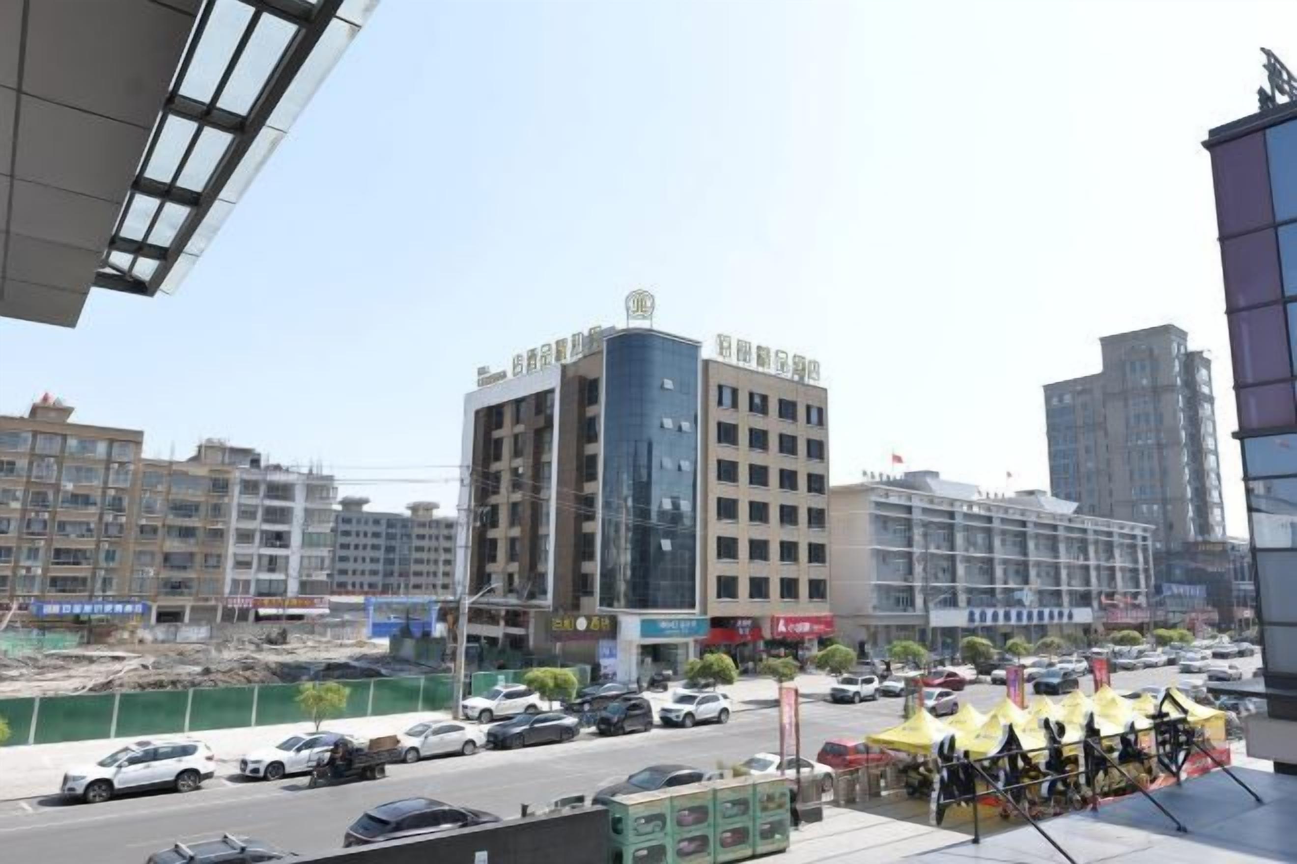A cityscape with modern buildings, a busy street with cars, and a construction site.