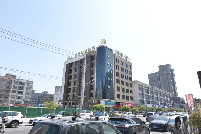 A multi-story building with a modern architectural design, featuring a prominent glass facade and a series of balconies.
