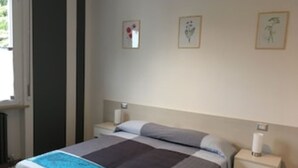 Une chambre à coucher avec un lit, des tables de chevet et des œuvres d’art murales.