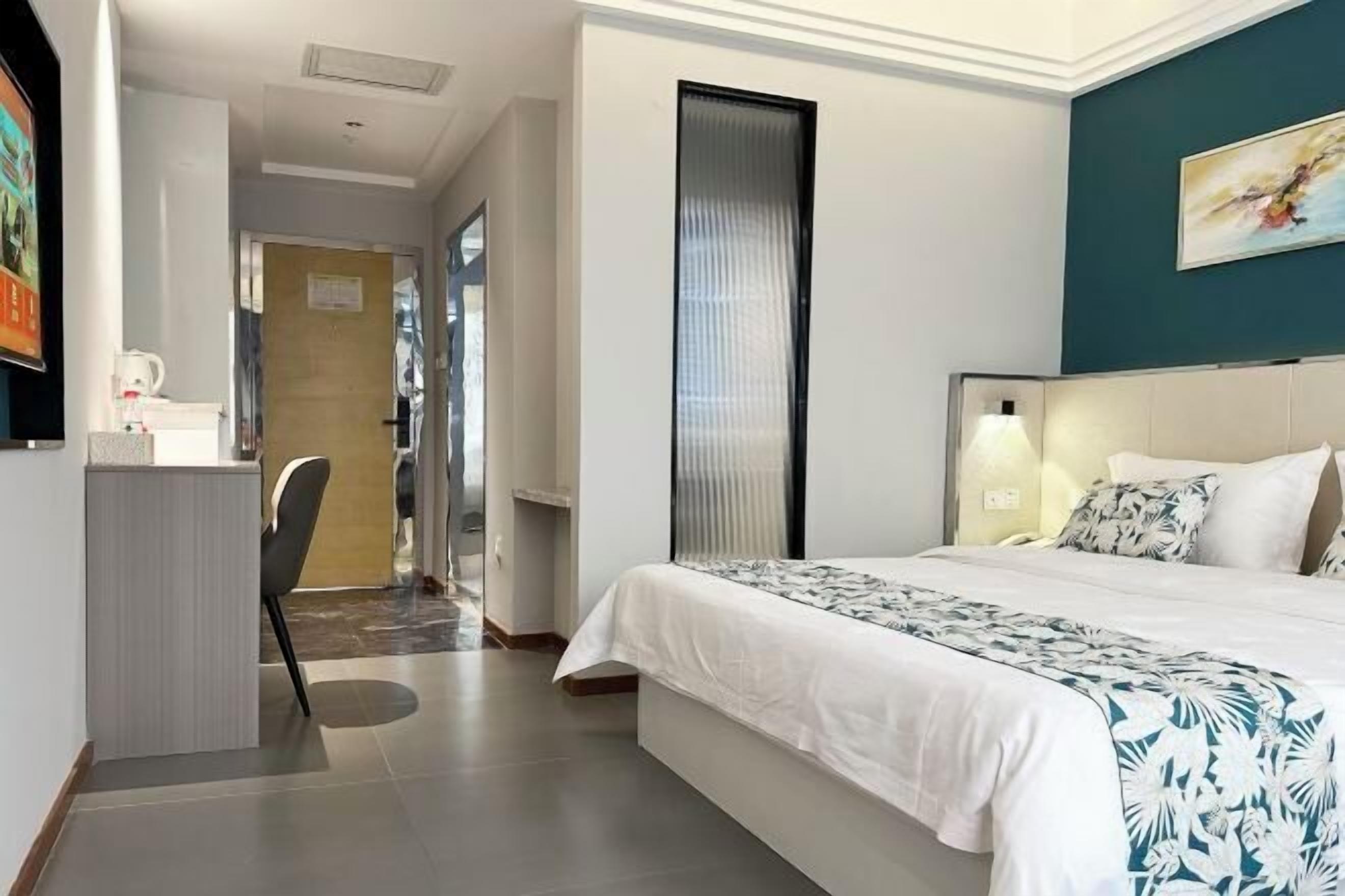 Quarto de hotel com uma cama, uma mesa e uma cadeira.