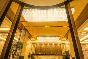 A hotel lobby with a reception desk, a chandelier, and a plant. - Sceneway Hotel (Quanjiao)