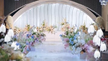 An arched entrance with floral decorations and hanging ornaments.