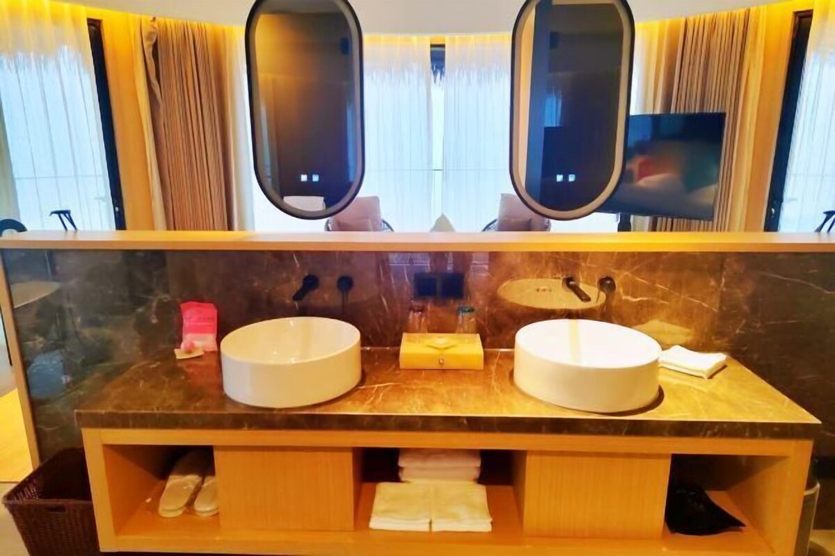 Ein Badezimmer mit zwei Waschbecken, einem Spiegel und einem Waschtisch mit Stauraum.