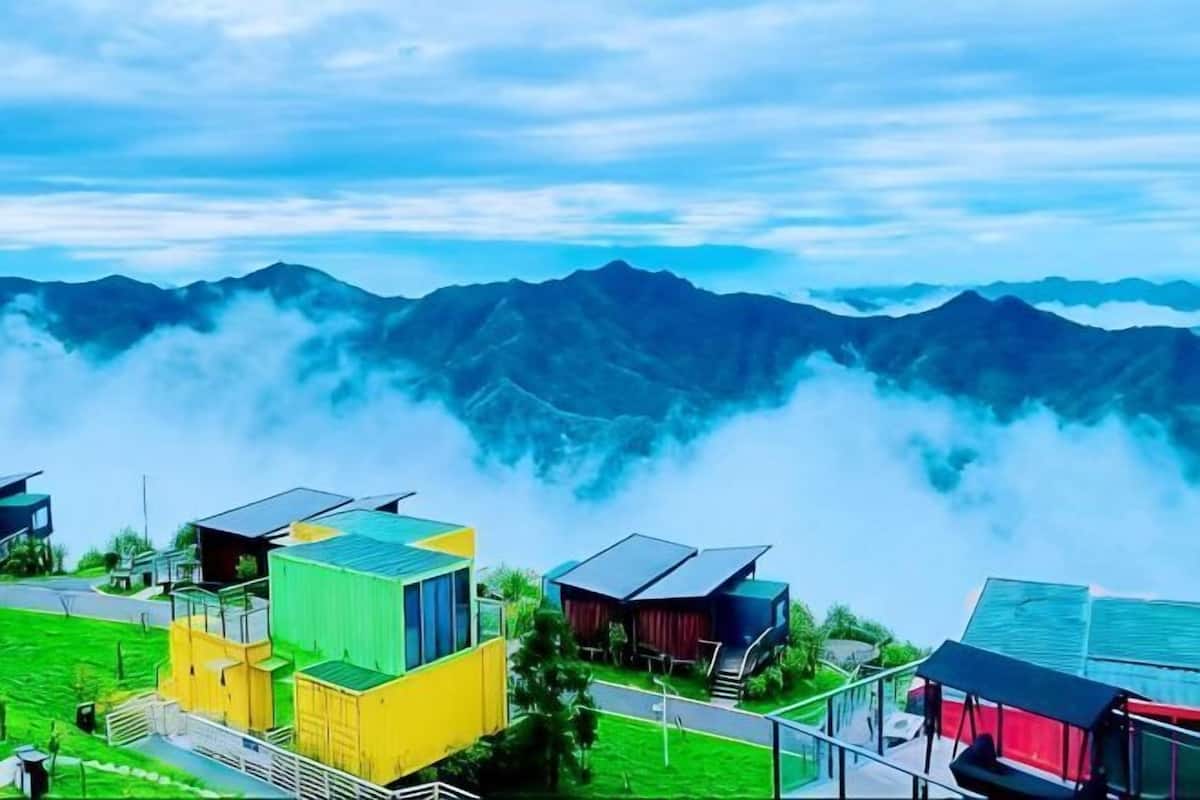 A mountainous landscape with buildings in the foreground.