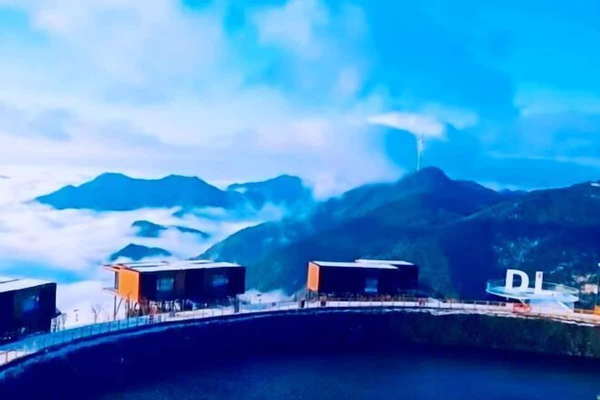 A mountainous landscape with a bridge and two modern buildings.
