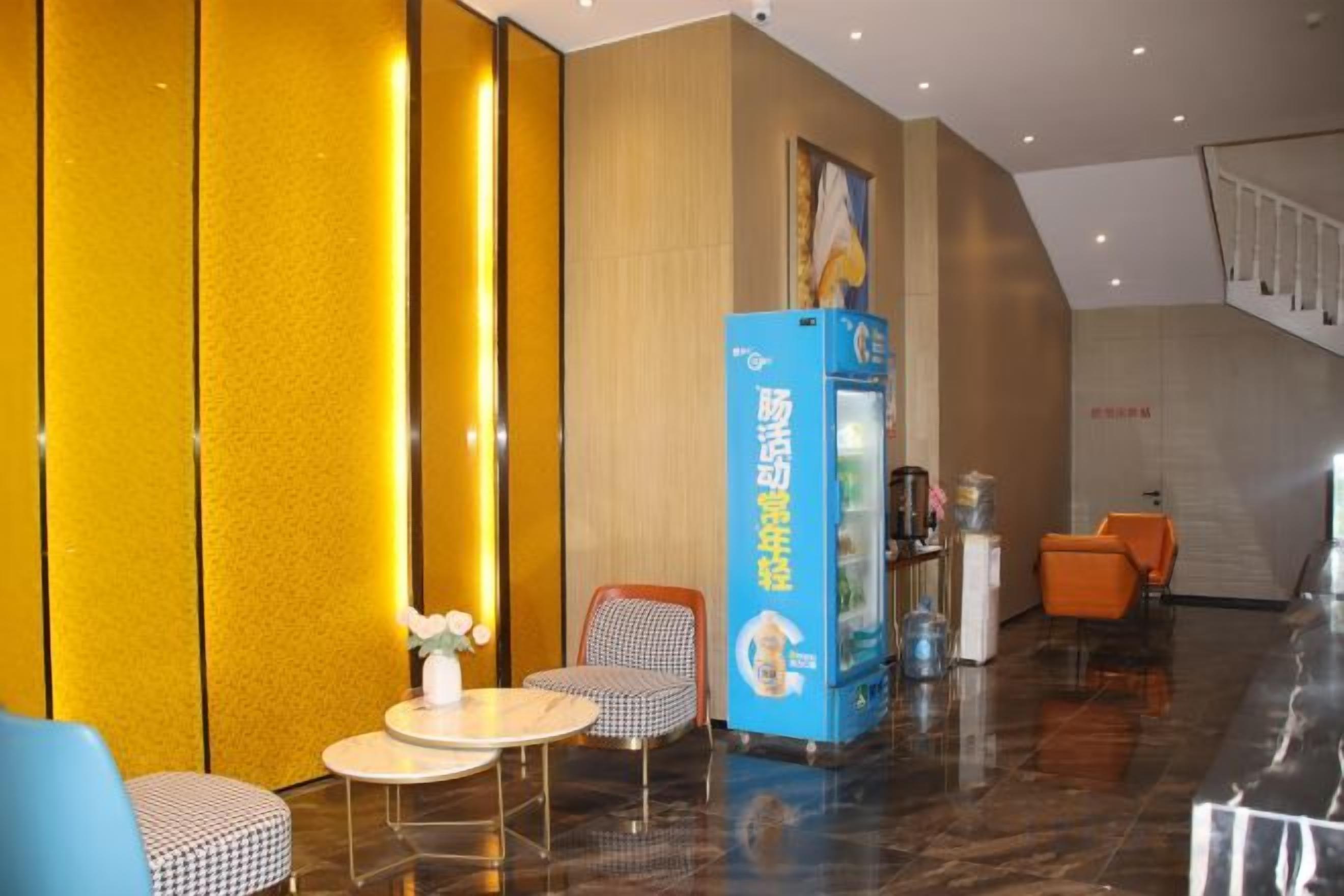 A hotel lobby with a reception desk, seating area, and a staircase.