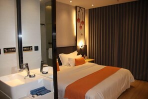 Quarto de hotel com uma cama grande, mesa de cabeceira, espelho, luminária na parede e cortina.