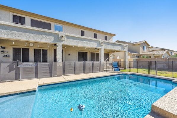 Enjoy a refreshing swim in the pool surrounded by a covered patio with outdoor seating.