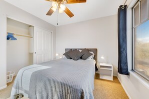 Cozy retreat with a large bed, wooden ceiling fan, and a spacious wardrobe.