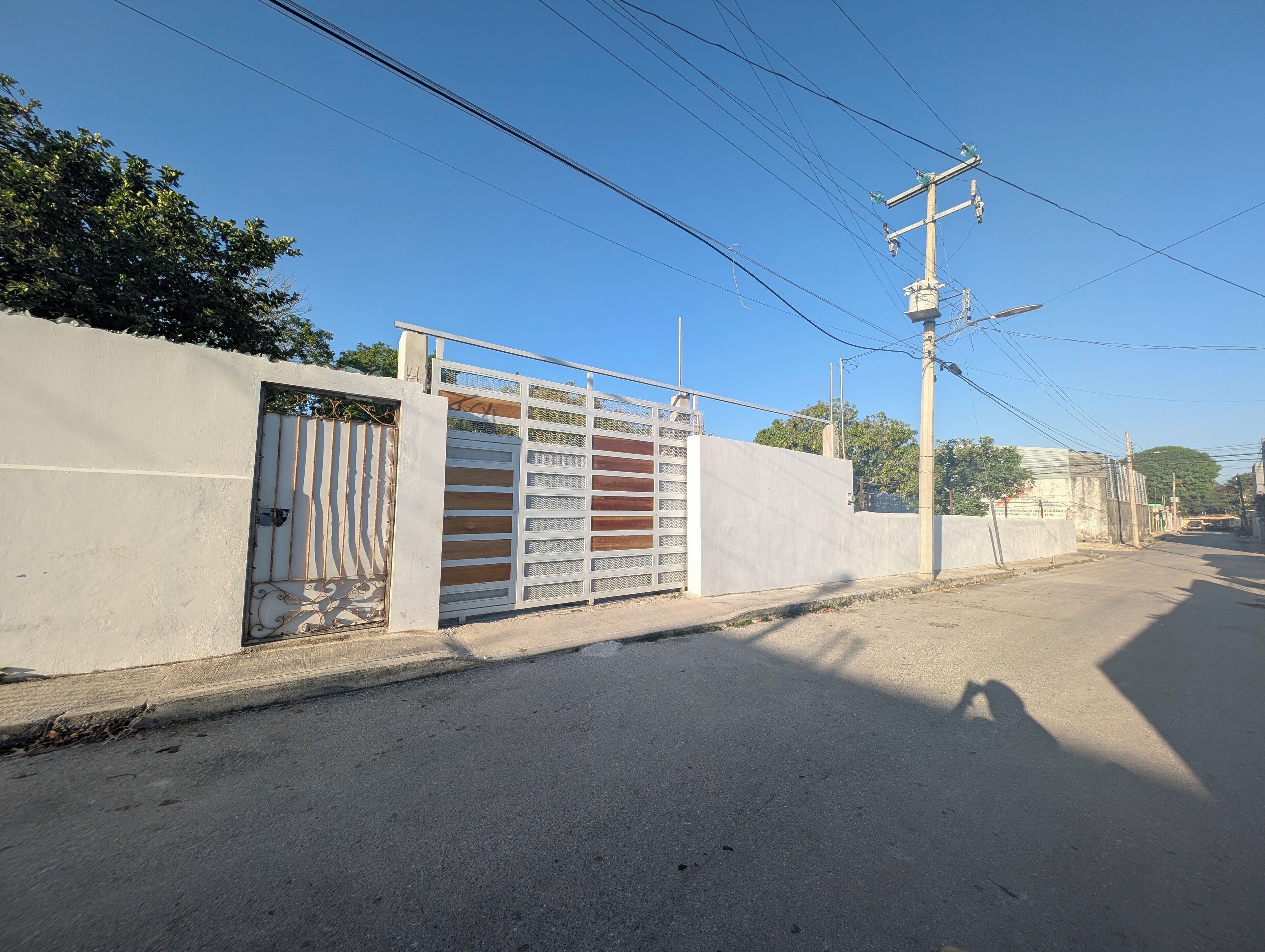 A gated entrance with a metal gate and a white wall.