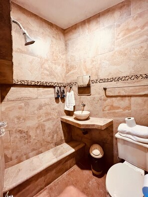 A bathroom with a bathtub, sink, toilet, and shower.