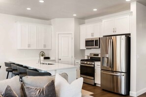Enjoy cooking in this well-equipped kitchen with a central island, sink, and seating area.
