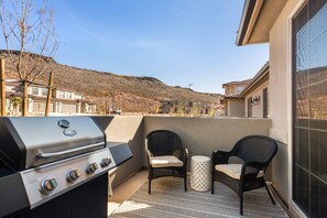 Enjoy al fresco dining on the patio with a barbecue grill and comfortable seating for two.