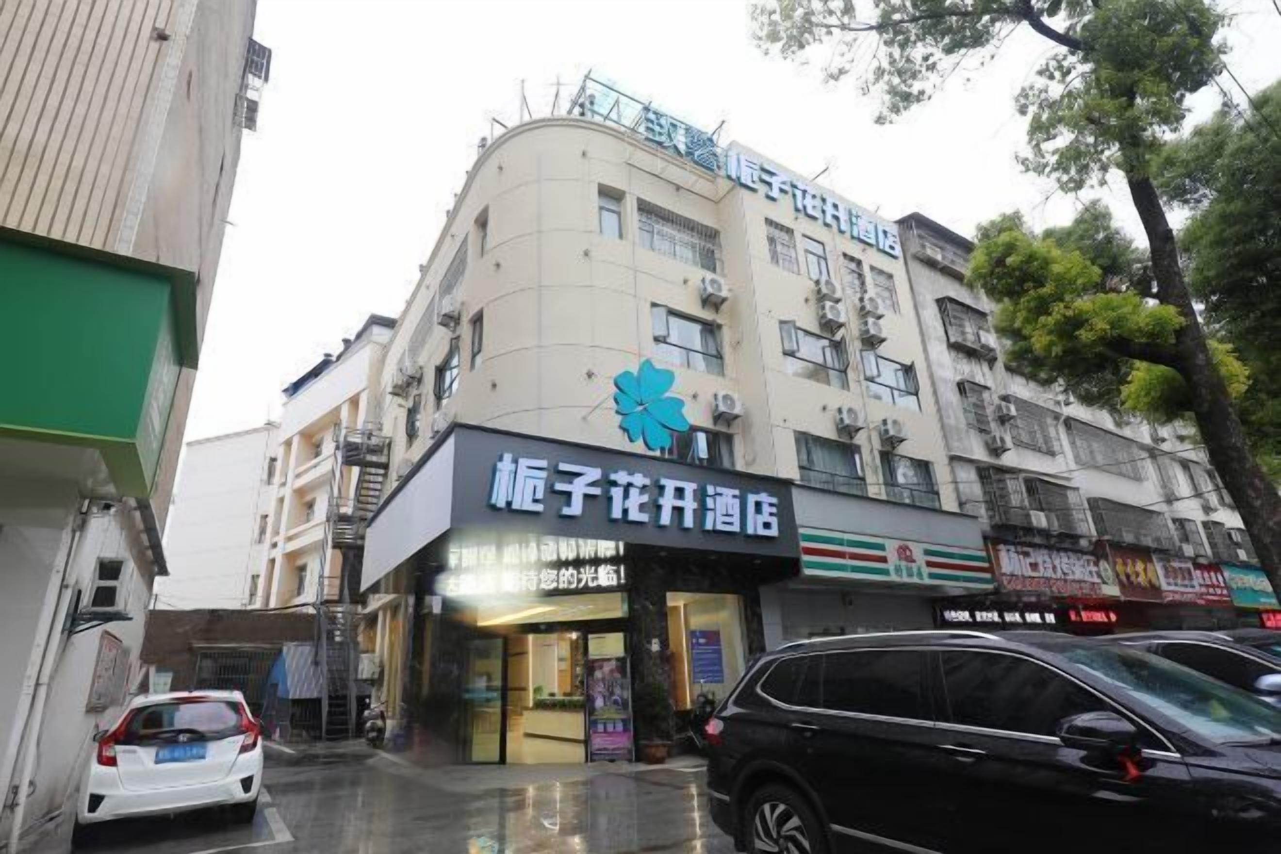 A building with a sign for "Kongzi Flower Hotel" and a 7-Eleven store.