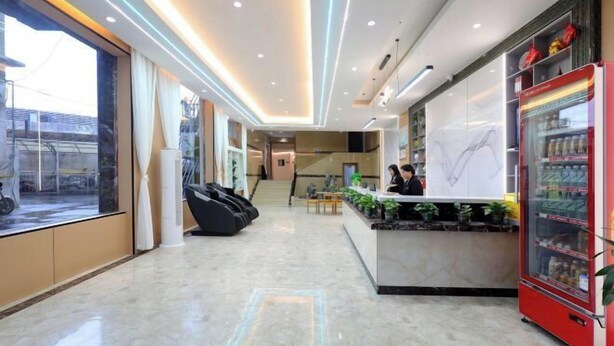 Eine moderne Hotelhalle mit Rezeption, Sitzgelegenheiten und einem Automaten.