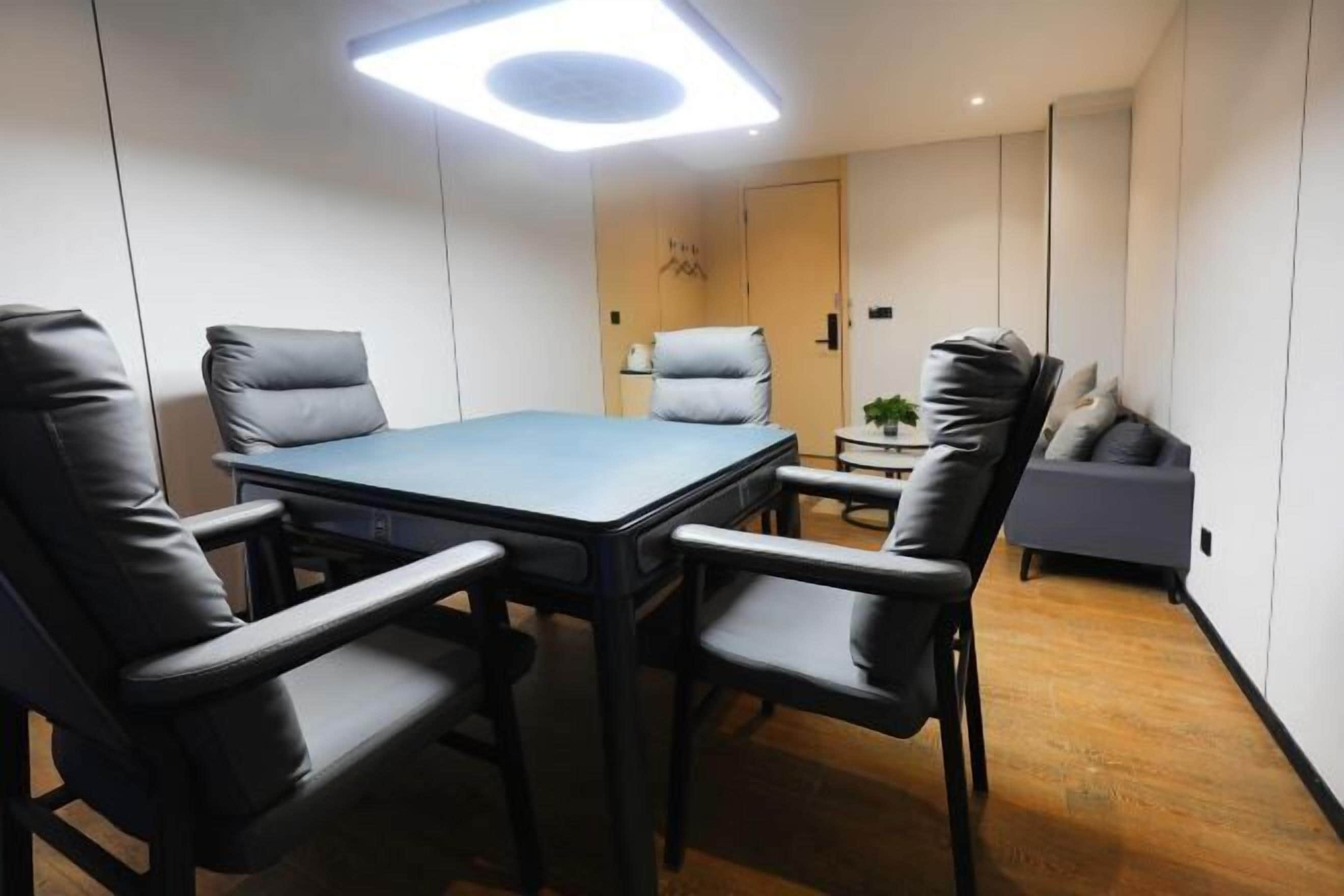 A conference room with a rectangular table, four chairs, a small side table, and a sofa.