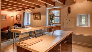 Una cocina moderna con vigas de madera, una encimera larga y un ventanal con vistas.