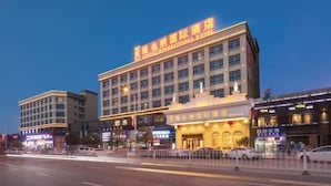 Ein mehrstöckiges Hotel mit auffälliger Beschilderung und einer gut beleuchteten Fassade.